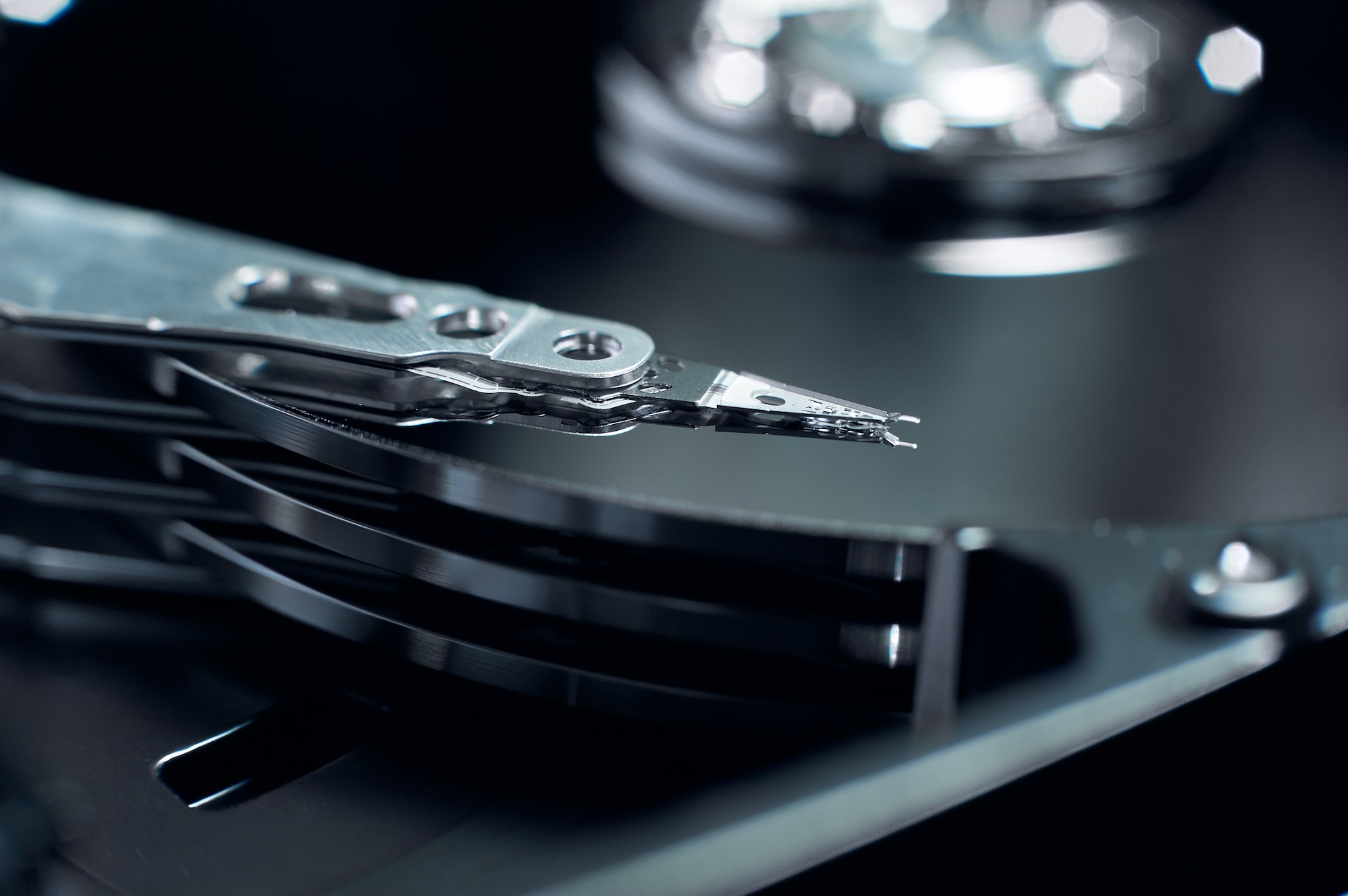 Disassembled hard disk. Read head, magnetic disk and spindle close-up.